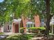 Exterior day time shot of a red brick townhome with a partial tree canopy at 9404 S Vicksburg Park Ct, Charlotte, NC 28210