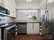 Modern kitchen with stainless steel appliances, sleek countertops, and wood-look flooring at 9404 S Vicksburg Park Ct, Charlotte, NC 28210