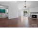 Open living room with hardwood floors, a fireplace, and sliding glass doors to the outside at 9404 S Vicksburg Park Ct, Charlotte, NC 28210