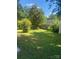 Spacious backyard with green grass, mature trees, a fence, and a storage shed at 9612 Farmridge Ln, Matthews, NC 28105