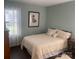 A cozy bedroom with a queen bed, a window with curtains, and wood-look flooring at 9612 Farmridge Ln, Matthews, NC 28105