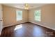 Bright bedroom with hardwood floors, ceiling fan, and two windows allowing ample natural light at 111 W Perry St, Heath Springs, SC 29058