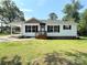 Charming single-story home featuring a well-maintained front lawn, covered carport, and classic black shutters at 111 W Perry St, Heath Springs, SC 29058
