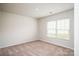 A bright bedroom featuring neutral carpet, a window with blinds, and fresh paint at 113 Rills Crossing Way, Troutman, NC 28166
