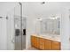 Well-lit bathroom featuring a double sink vanity, large mirror, and glass-enclosed shower at 11917 Ulsten Ln, Huntersville, NC 28078
