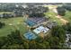 Aerial view showcasing golf course, tennis courts, swimming pools, and clubhouse within a lush, green landscape at 11917 Ulsten Ln, Huntersville, NC 28078