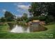 Serene view of the 'Northstone Country Club' entrance with a waterfall, pond, and beautifully landscaped grounds at 11917 Ulsten Ln, Huntersville, NC 28078