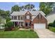 Charming two-story brick home with a manicured lawn and attached two-car garage at 11917 Ulsten Ln, Huntersville, NC 28078