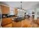 Beautiful kitchen with an island, wood cabinets, granite countertops, and an open view of the living room at 11917 Ulsten Ln, Huntersville, NC 28078