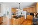 Well-lit kitchen with a central island, wood cabinets, granite countertops, and modern appliances at 11917 Ulsten Ln, Huntersville, NC 28078