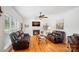 Bright living room featuring a cozy fireplace, hardwood floors, and comfortable leather sofas at 11917 Ulsten Ln, Huntersville, NC 28078
