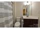 Cozy bathroom features a vanity with dark wood cabinets, a toilet, and a shower with a patterned curtain at 1329 Jacemans Way, Cornelius, NC 28031