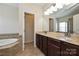 Well-lit bathroom featuring a double vanity with a marble countertop and a separate soaking tub and shower at 1329 Jacemans Way, Cornelius, NC 28031