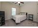 Carpeted bedroom with a ceiling fan, a bed, a small side table, and a shelf at 1329 Jacemans Way, Cornelius, NC 28031