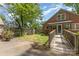 Inviting backyard featuring a ramp, patio area, mature trees, and partial fencing at 1400 Matheson Ave, Charlotte, NC 28205