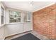 Enclosed sunroom featuring an exposed brick wall, natural light, and access to the outdoors at 1400 Matheson Ave, Charlotte, NC 28205