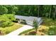 A bird's eye view of a light blue house with a green lawn and tall, dense trees surrounding the property at 144 Stoneybrook Rd, Salisbury, NC 28147