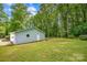 View of the home's exterior, showcasing the expansive yard, mature trees, and attached garage at 144 Stoneybrook Rd, Salisbury, NC 28147