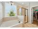 Bright bathroom with a soaking tub, separate shower, and tiled walls, creating a spa-like retreat at 1478 Imperial Ct, York, SC 29745
