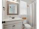 Well-lit bathroom features a single sink with a decorative mirror and a toilet with a window view at 1478 Imperial Ct, York, SC 29745