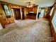 Spacious carpeted living room featuring wood paneling and a view of the kitchen at 1585 Salem Church Rd, Lincolnton, NC 28092