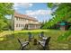Landscaped backyard featuring a fire pit surrounded by chairs, ideal for outdoor gathering at 1805 Sutter Creek Dr, Waxhaw, NC 28173