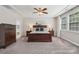 Well-appointed bedroom featuring large windows, tray ceilings and a dresser leading to the bathroom at 1805 Sutter Creek Dr, Waxhaw, NC 28173