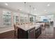 Bright kitchen features a granite island with seating and stainless steel sink, with light from large windows at 1805 Sutter Creek Dr, Waxhaw, NC 28173
