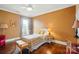 Comfortable bedroom with hardwood floors, natural light from the window, and a red sitting chair at 1974 Links View Dr, Fort Mill, SC 29707