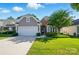 Charming home with a two-car garage, stone accents, and a well-manicured lawn at 1974 Links View Dr, Fort Mill, SC 29707