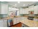 Kitchen with granite countertops, white cabinets, stainless steel appliances, and view to the living room at 1974 Links View Dr, Fort Mill, SC 29707