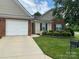 Charming single-story home boasts manicured lawn, brick accents, and attached garage for comfortable suburban living at 204 Woodbridge Cir, Mount Holly, NC 28120