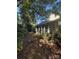 Image shows the home's overgrown backyard, featuring a sunroom with bright windows at 20807 Willow Pond Rd, Cornelius, NC 28031
