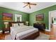 Bright bedroom with hardwood floors, wood-paneled walls, ceiling fan, and a walk-in closet at 233 Sellars Rd, Kings Mountain, NC 28086