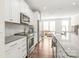 Modern kitchen with white cabinets, stainless steel appliances, granite countertops, and hardwood floors at 3007 Citizens Ln, Charlotte, NC 28205