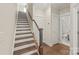 Staircase with wooden railing and new flooring, next to a hallway with a convenient powder room at 3007 Citizens Ln, Charlotte, NC 28205