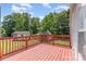 A wooden back deck with red railings overlooks the expansive backyard with mature trees and a storage shed at 3585 Woodstream Dr, Maiden, NC 28650