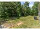 Lush backyard features a large grassy area, shade trees, and an air conditioning unit, creating a serene outdoor space at 3585 Woodstream Dr, Maiden, NC 28650