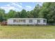 Traditional single-story home with white siding, complemented by a well-maintained green lawn and surrounding trees at 3585 Woodstream Dr, Maiden, NC 28650
