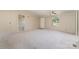 Bright, carpeted living room with neutral walls, a ceiling fan, and multiple windows, offering a comfortable living space at 3585 Woodstream Dr, Maiden, NC 28650