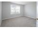 Cozy bedroom featuring neutral paint and carpeting, a large window with neighborhood views and plenty of light at 4392 Sunset Rose Dr, Fort Mill, SC 29708