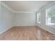 Bright, empty bedroom with hardwood floors, white trim, and abundant natural light from the double windows at 4392 Sunset Rose Dr, Fort Mill, SC 29708