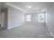 Large bedroom features neutral paint, carpeted floors, tray ceiling, and ample natural light from many windows at 4392 Sunset Rose Dr, Fort Mill, SC 29708