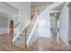 Spacious foyer featuring hardwood floors, a staircase with carpet runner and banister, and ample natural light at 4392 Sunset Rose Dr, Fort Mill, SC 29708