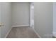 Hallway with neutral colored walls, carpet, and a view into another room at 4392 Sunset Rose Dr, Fort Mill, SC 29708