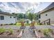 Charming backyard with lake views between two light colored houses, featuring a stone path and garden at 445 Sundown Rd, Mooresville, NC 28117