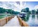 A private wooden dock leading to a covered boat lift on a scenic lake at 445 Sundown Rd, Mooresville, NC 28117