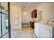 A modern laundry room with stainless steel utility sink and white front load washer and dryer at 445 Sundown Rd, Mooresville, NC 28117