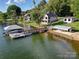 Waterfront property featuring a private dock, boat lift, and outdoor seating area at 445 Sundown Rd, Mooresville, NC 28117