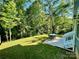 Lush backyard featuring a patio area with outdoor furniture and mature trees at 5005 Blue Serenity Ct, Denver, NC 28037